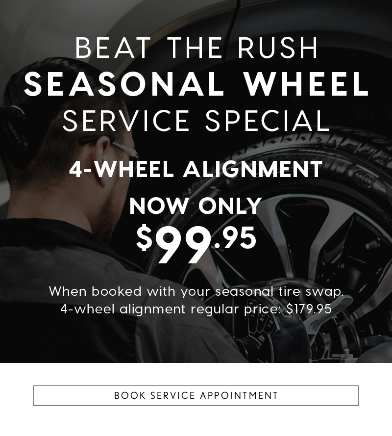 Service technician inspecting a vehicle wheel with text promoting a Seasonal Wheel Service Special: 4-wheel alignment now only $99.95 when booked with a seasonal tire swap, regular price $179.95. Button at the bottom reads 'Book Service Appointment'.